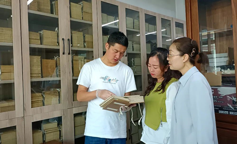 張旻（左）在大通縣圖書館了解、翻閱清代印制的經(jīng)史子集典籍