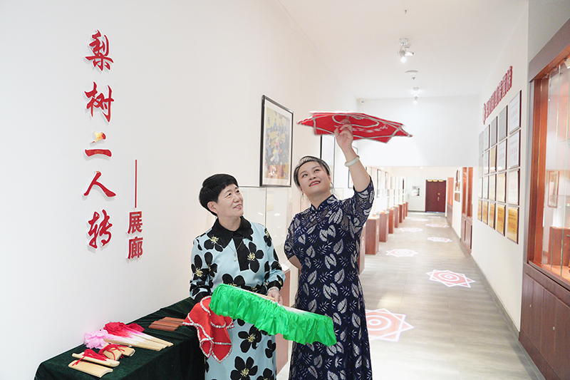 2023年6月29日，在吉林省梨樹縣地方戲曲劇團梨樹二人轉(zhuǎn)展廊，團長趙丹丹（右一）為作家龔保華講解二人轉(zhuǎn)技巧。