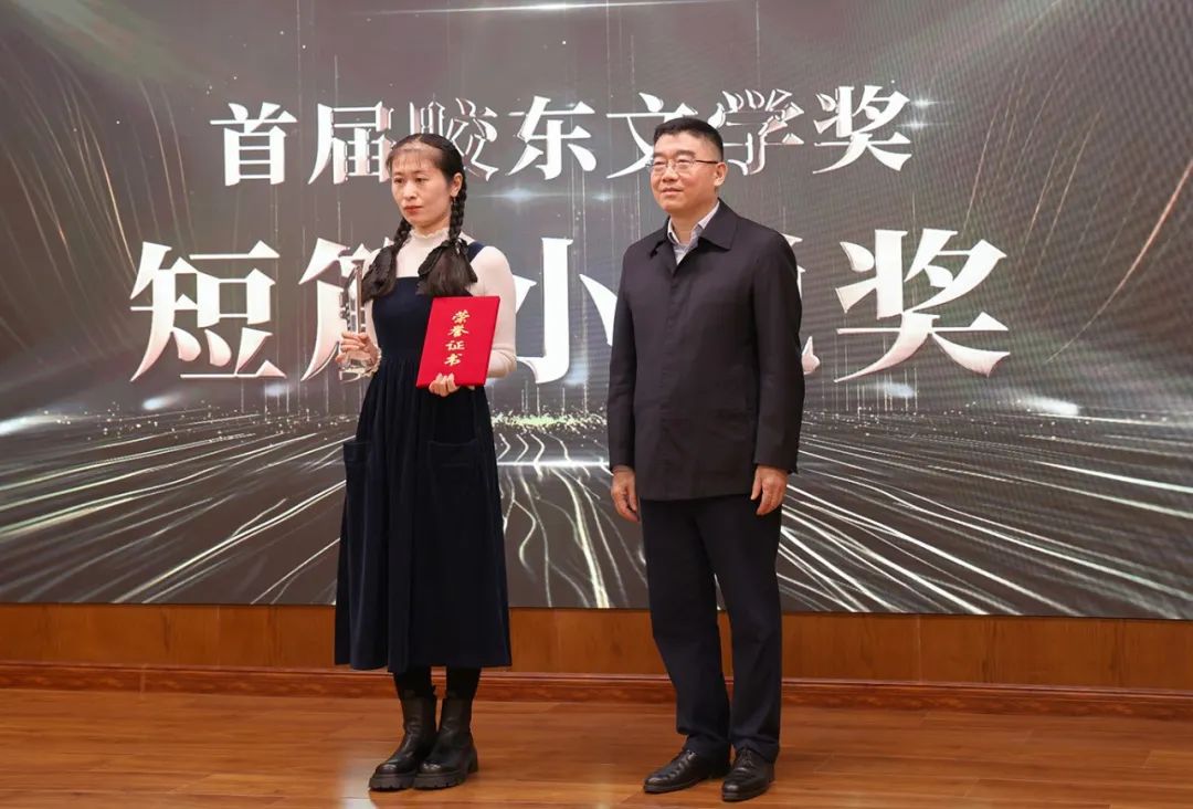 山東省作協(xié)黨組書記、副主席趙藝?。ㄓ乙唬? 為短篇小說獎獲得者王銘嬋頒獎