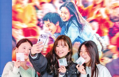 2月18日，觀眾在貴州省黔西市一家影院的電影海報(bào)前留影。 新華社發(fā)