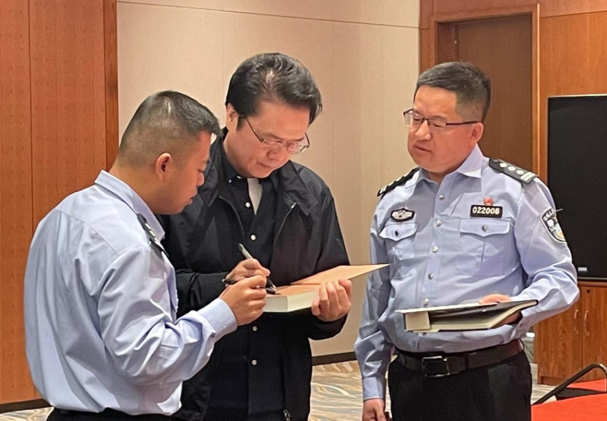 活動期間，陳彥（圖中）在給警營作家簽名。