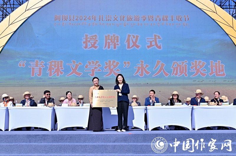 陳亞軍主編代表《民族文學(xué)》向阿壩縣授牌，紅梅部長(zhǎng)接牌。