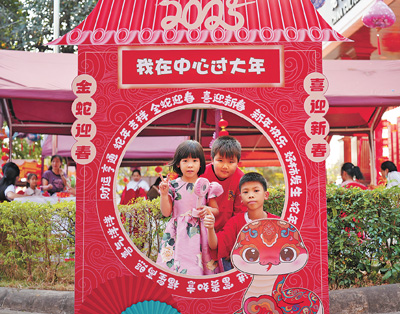 老撾民眾在“歡樂春節(jié)”廟會現(xiàn)場設(shè)立的新春祈福打卡點拍照。  坎帕頌攝